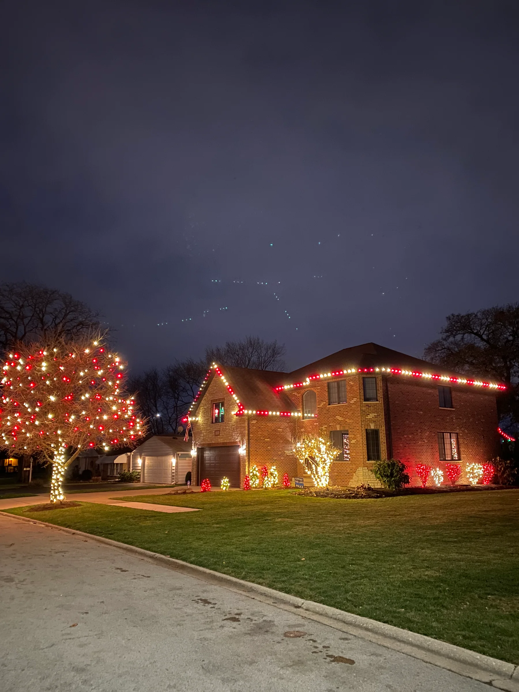 Colorful professional holiday lighting across a home and landscape
