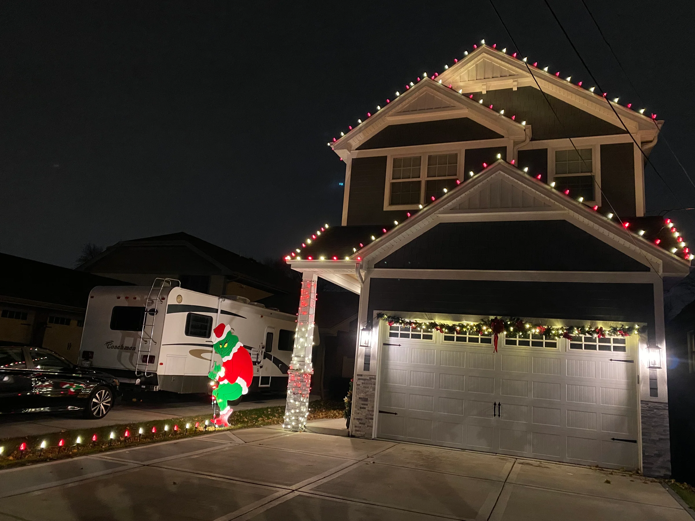 Two-story home with alternating red and white holiday lights