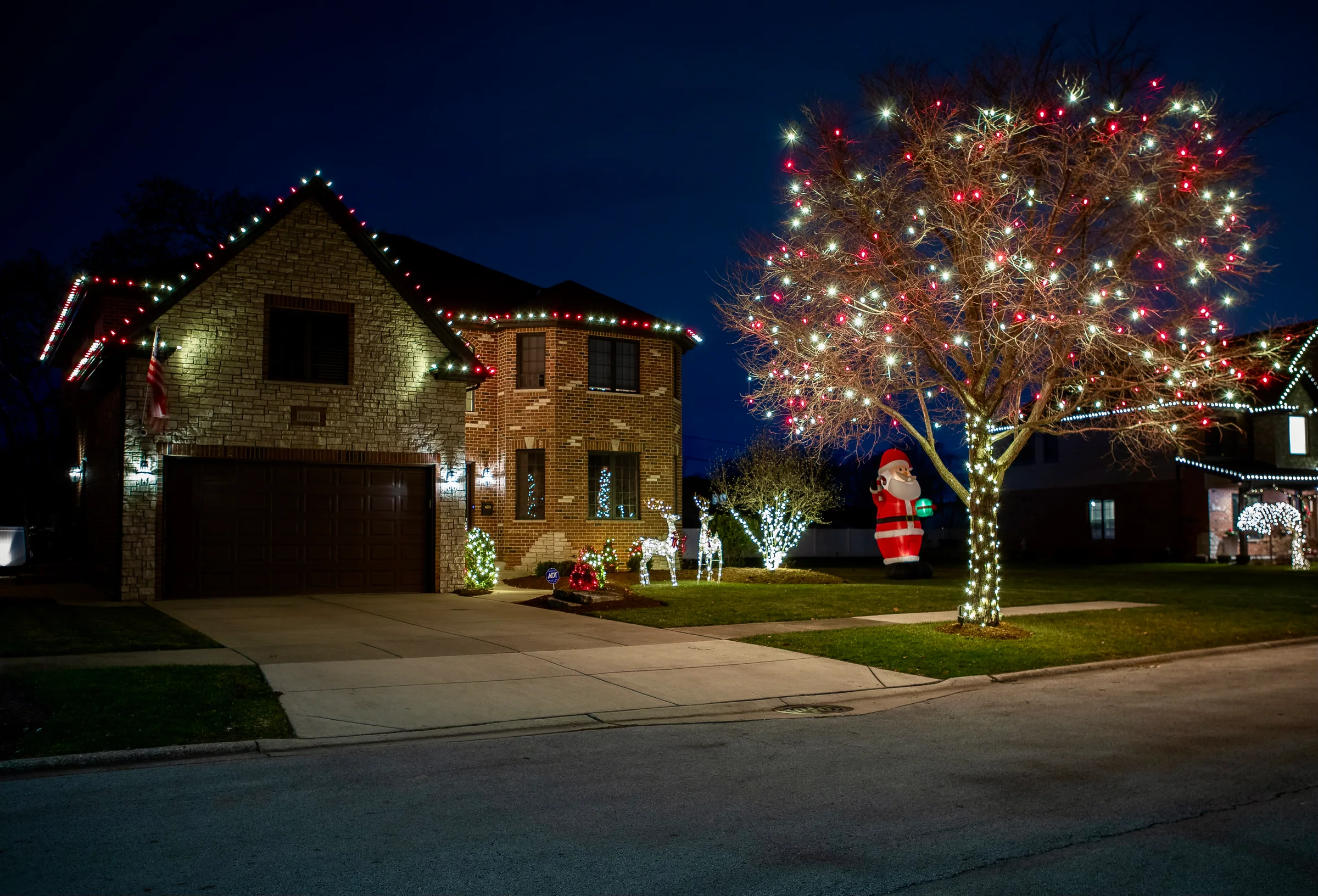 Red and white roofline with a large illuminated front-yard tree