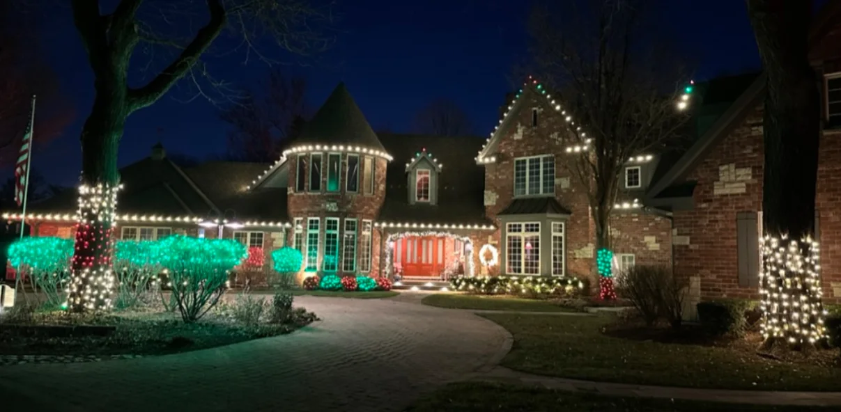Large home framed in white light with green and red accents