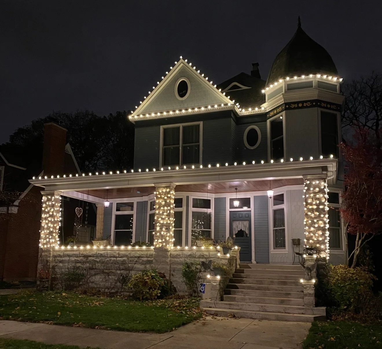 Historic-style home traced in precise warm-white Christmas lights